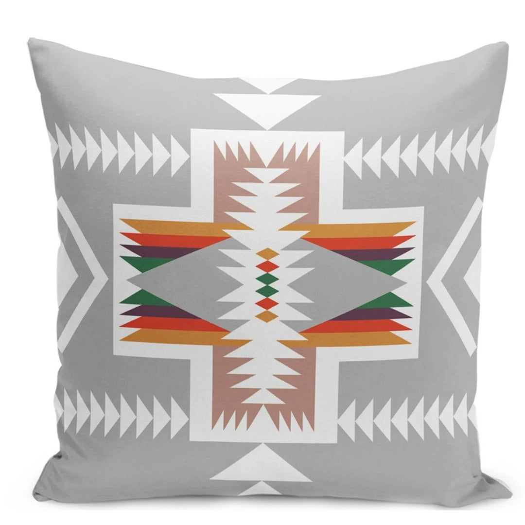 Grey cushion cover with a white geometric cross and rust, green and yellow details.
