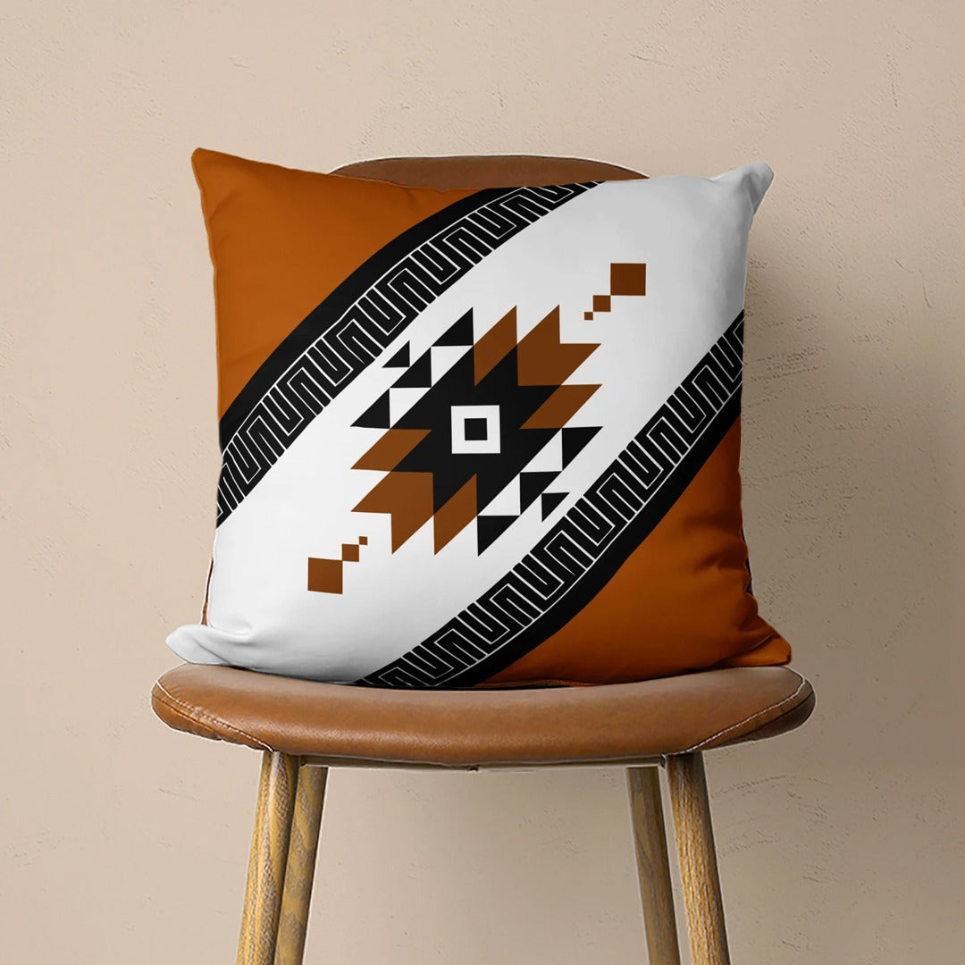 Cushion cover with a diagonal white band and a black and rust stepped diamond.