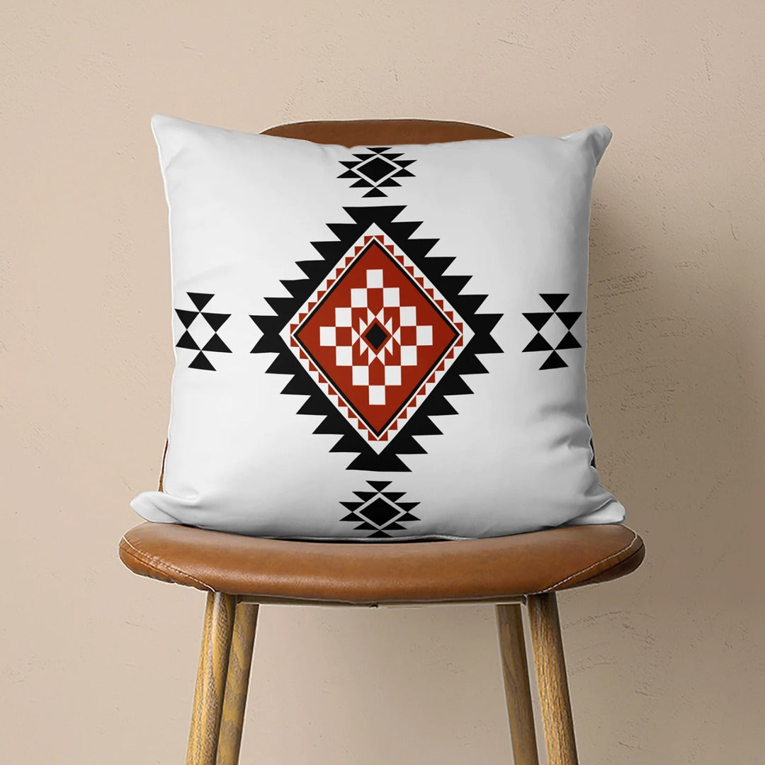 White cushion cover with a black and rust stepped diamond and small black motifs.