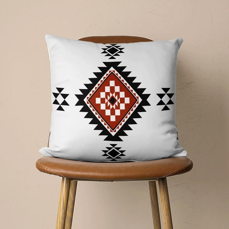 White cushion cover with a black and rust stepped diamond and small black motifs.