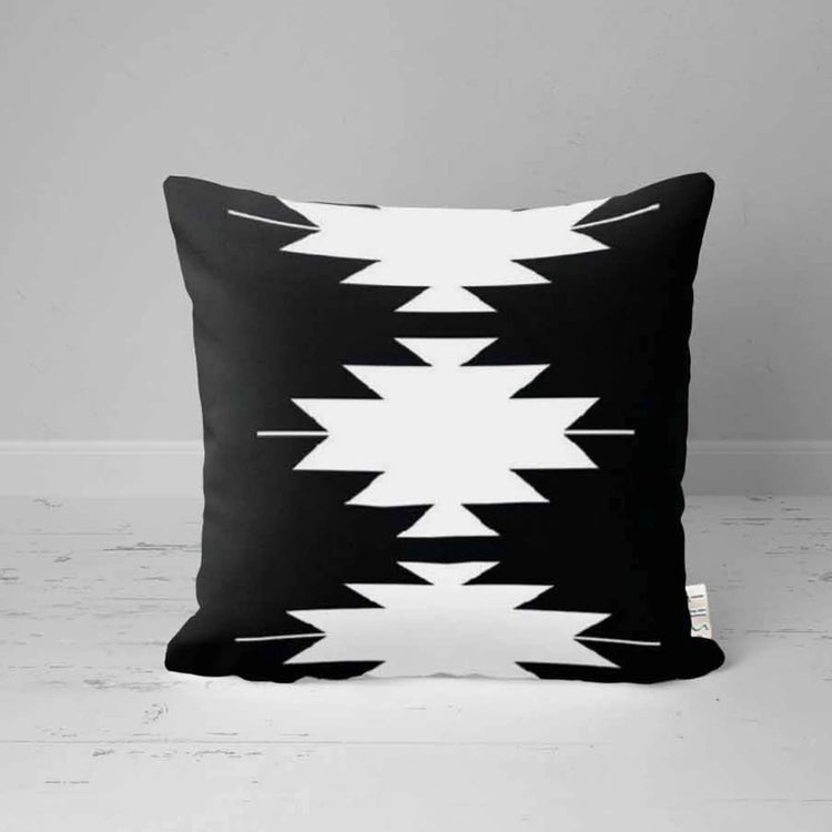 Black cushion cover with bold white stepped geometric shapes.