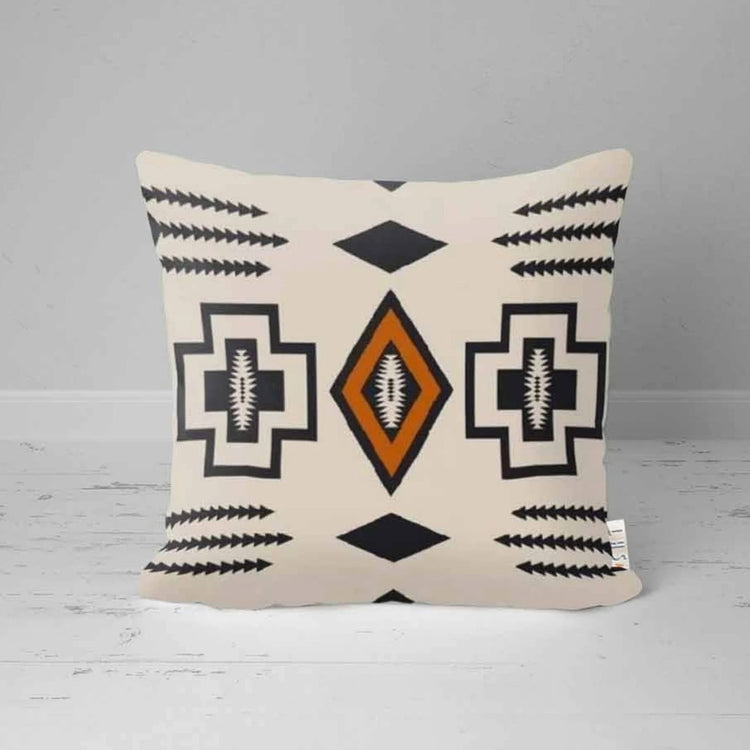 Cream cushion cover with black geometric outlines and a central rust diamond.