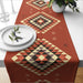 Rust-coloured table runner with multicoloured geometric diamond motifs.