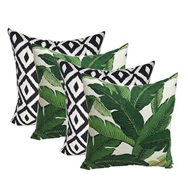 Four cushion covers with green leaves and black and white diamond patterns.