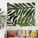 Cream tapestry with large dark green tropical leaves.
