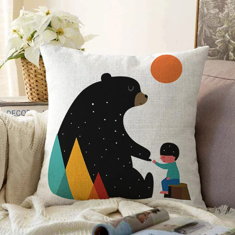 White cushion cover with a black bear, a small child and an orange sun.