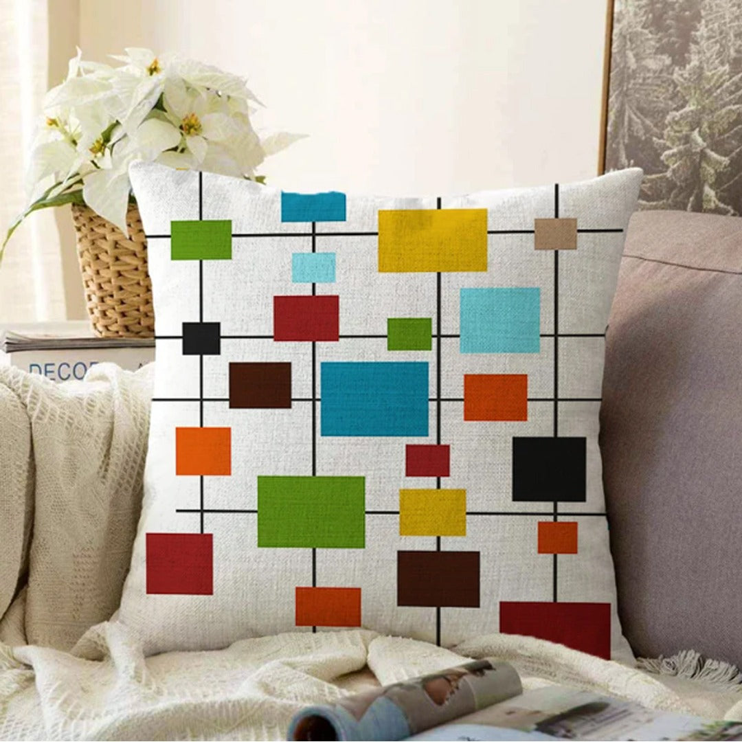 White cushion cover with colourful small rectangles connected by thin black lines.
