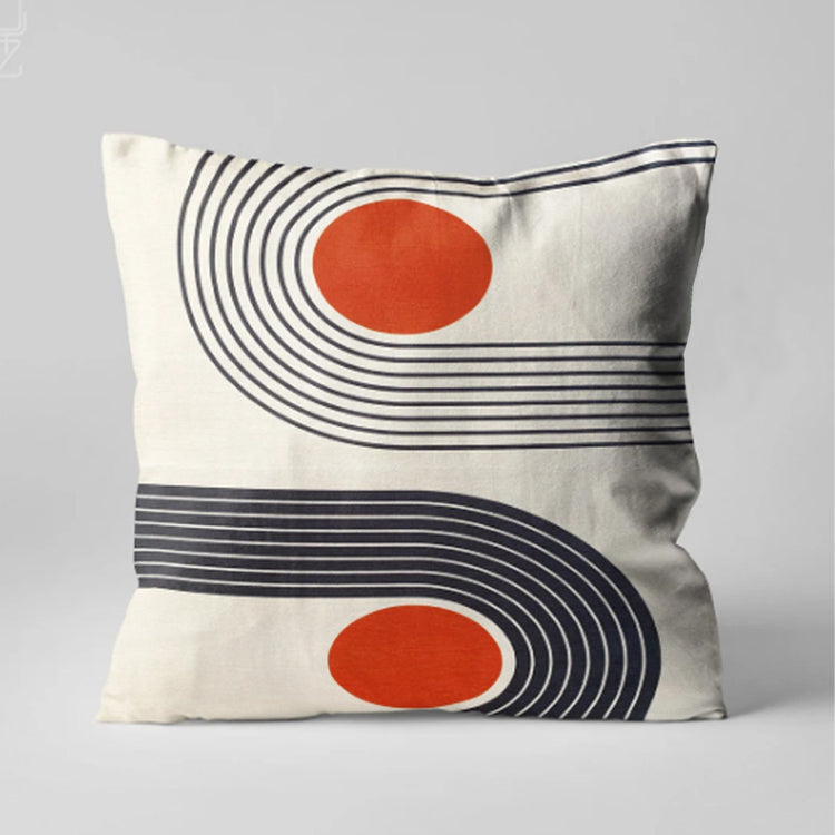 Cream cushion cover with orange circles inside sweeping black curved lines.