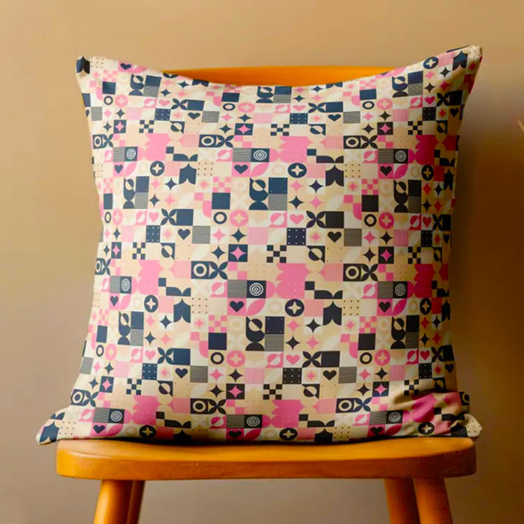 Cushion cover with a small pink, navy, cream and green geometric patchwork pattern.