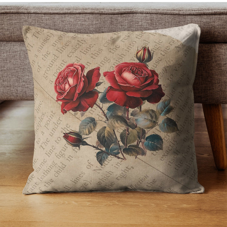 Beige cushion cover with a cluster of red roses and green leaves.