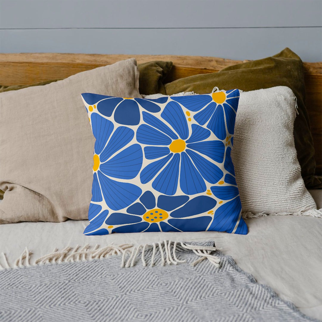 Blue cushion cover with large cream outlined flowers and yellow centres.