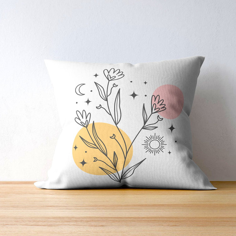White cushion cover with fine black flower drawings over yellow and pink circles.