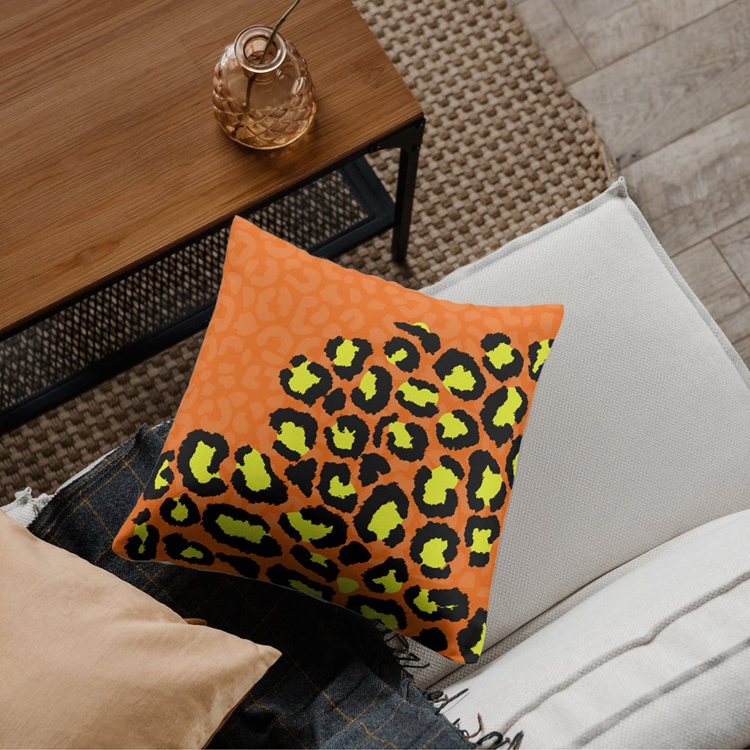 Cushion cover with bright green, yellow and black leopard spots beside an orange panel.