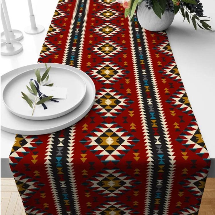 Red table runner with multicoloured geometric diamonds and striped borders.