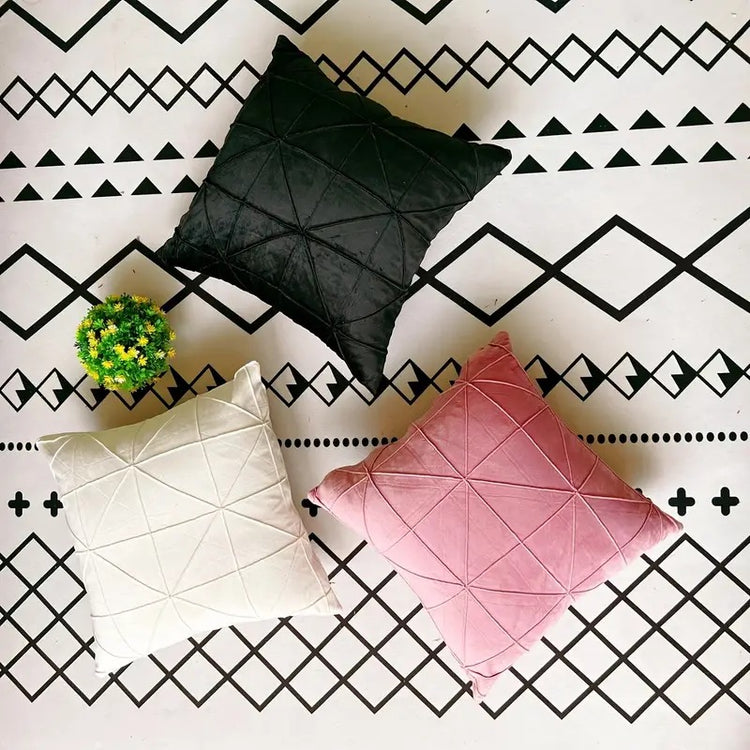 Black, white and pink cushion covers with geometric stitched lines.