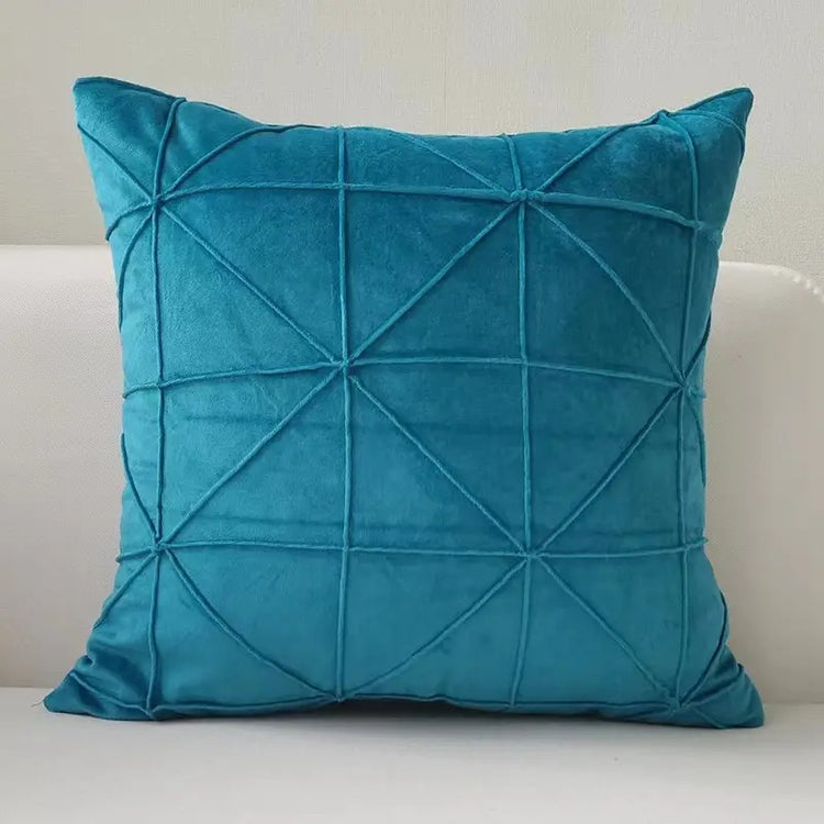 Teal cushion cover with intersecting geometric stitched lines.