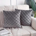 Two grey cushion covers with diamond stitching on a sofa.
