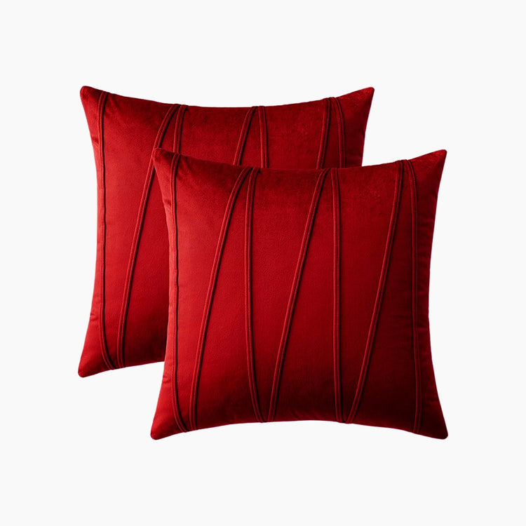 Two red cushion covers with long angular stitched lines.