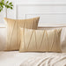 Cream square and rectangular cushion covers with angular stitched lines on a bed.