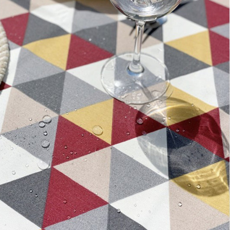 Close-up of water droplets on a geometric triangle-pattern tablecloth.