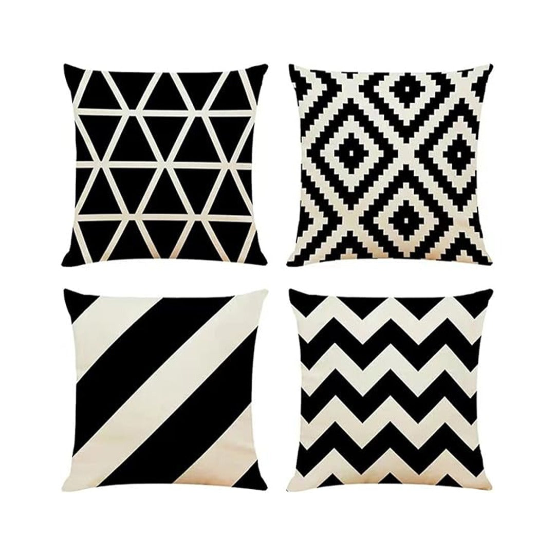 Four black and cream cushion covers with triangles, diamonds, diagonal stripes and zigzags.
