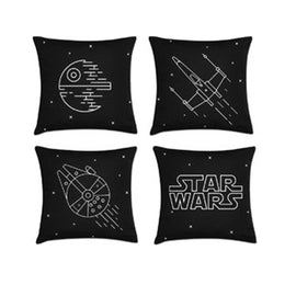 Four black cushion covers with Star Wars lettering and white spacecraft line drawings.
