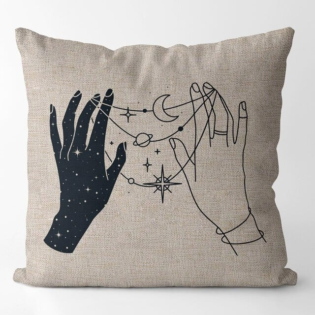 Beige cushion cover with two hands surrounded by fine celestial symbols.