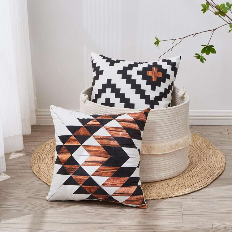 Two rust, black and cream geometric cushion covers beside a woven basket.