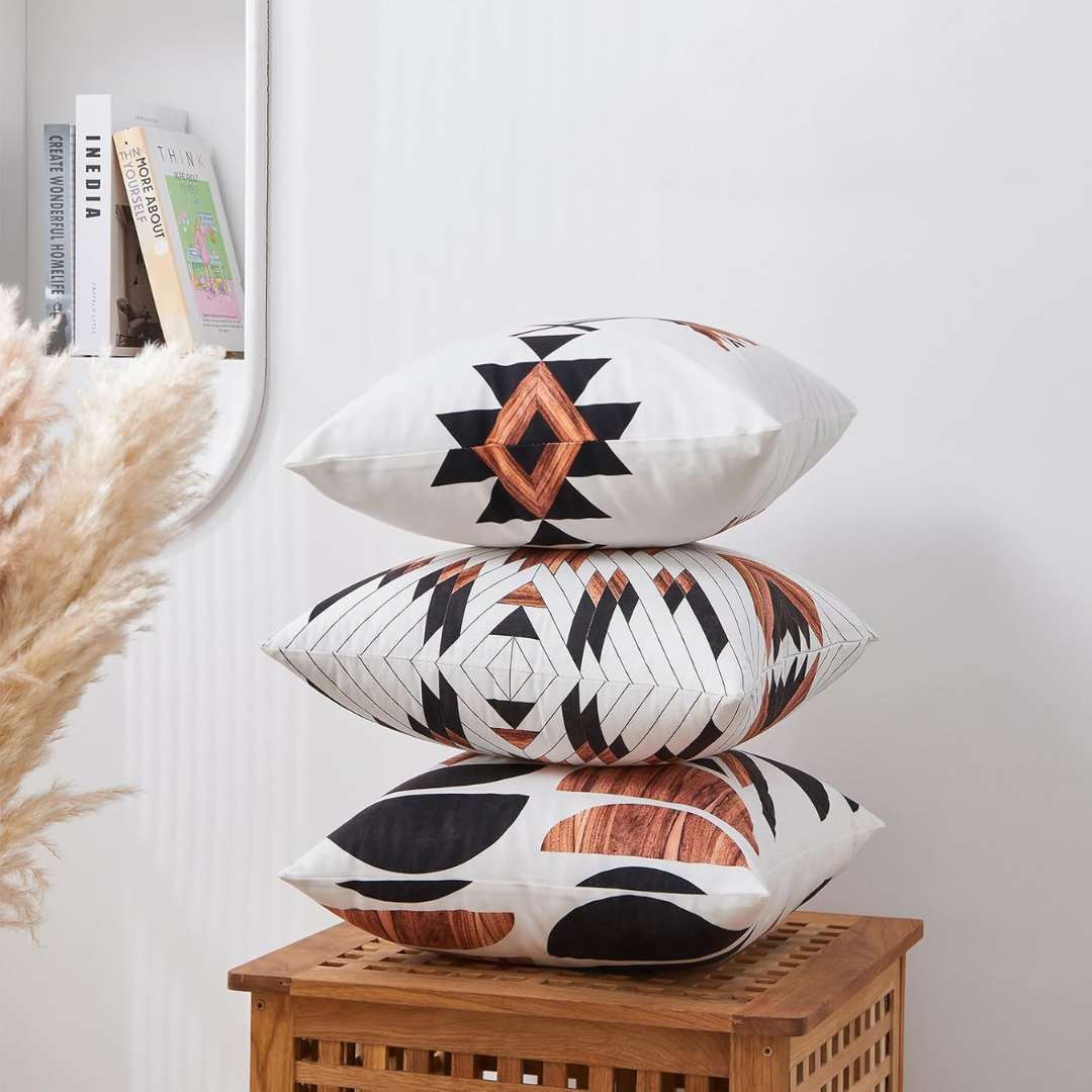 Stacked rust, black and cream cushion covers showing different geometric prints.