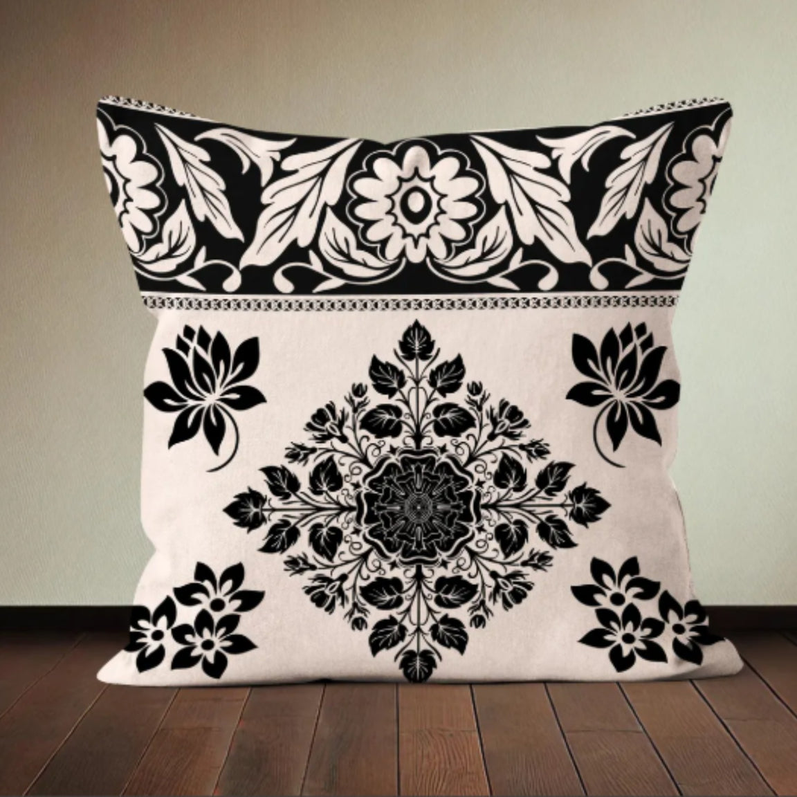 Cream cushion cover with a black floral medallion and ornate top border.