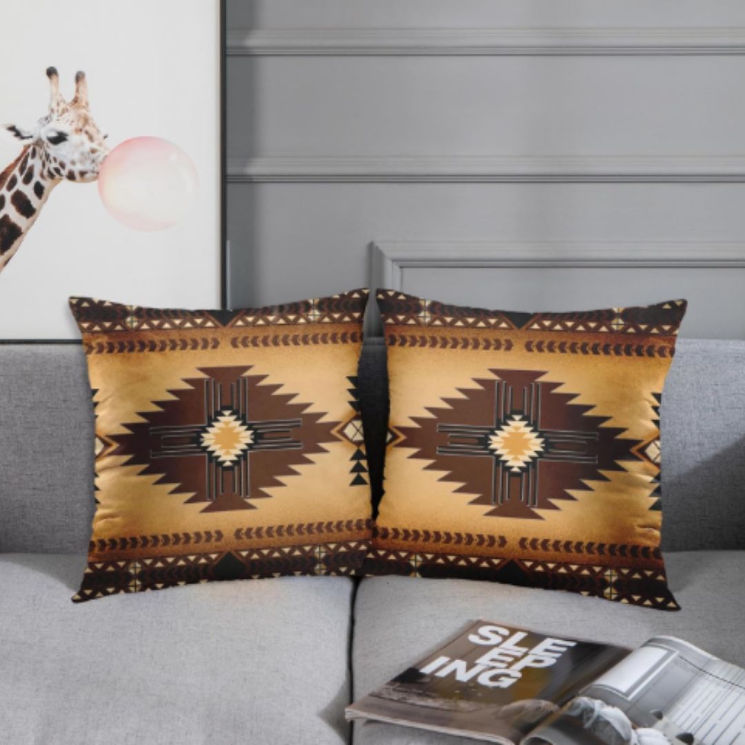 Two ochre cushion covers with dark brown stepped diamonds and patterned borders on a grey sofa.