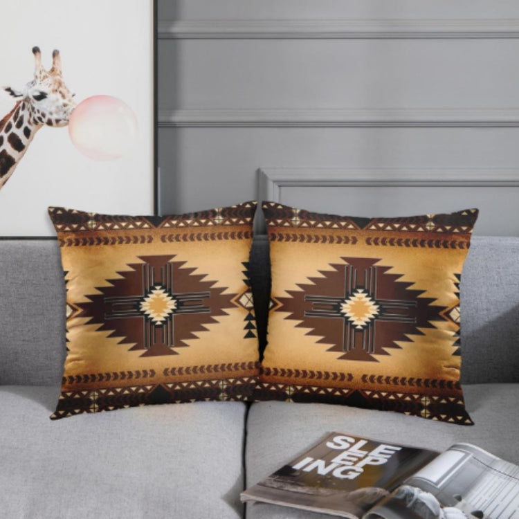 Two ochre cushion covers with dark brown stepped diamonds and patterned borders on a grey sofa.