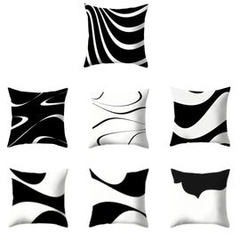 Seven black and white cushion covers with flowing abstract line patterns.