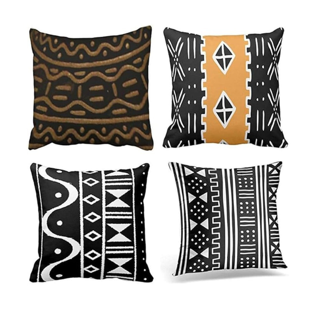 Four cushion covers with black, white and ochre geometric patterns.