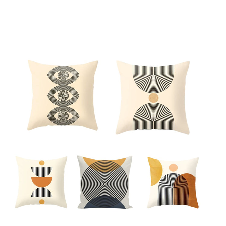 Five cream cushion covers with abstract semicircles, arches and eye-like shapes.