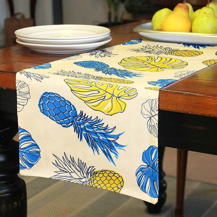 Cream table runner with blue and yellow pineapple prints.