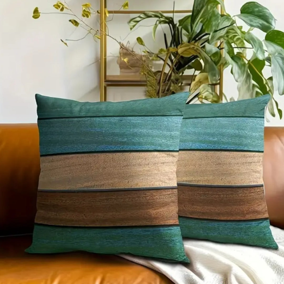 Two green, cream and brown striped cushion covers displayed against a mustard sofa.