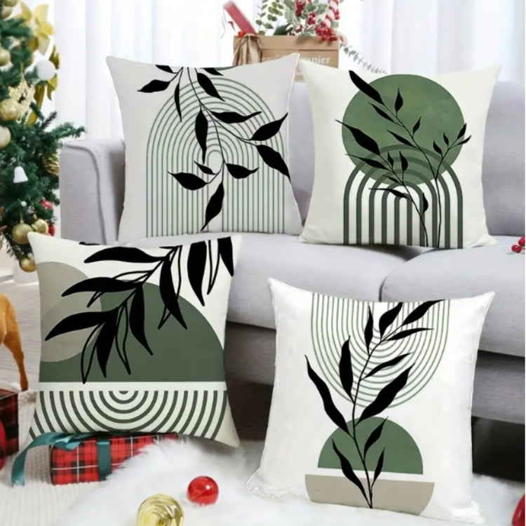 Four white cushion covers with black leaves over green shapes and fine line patterns.