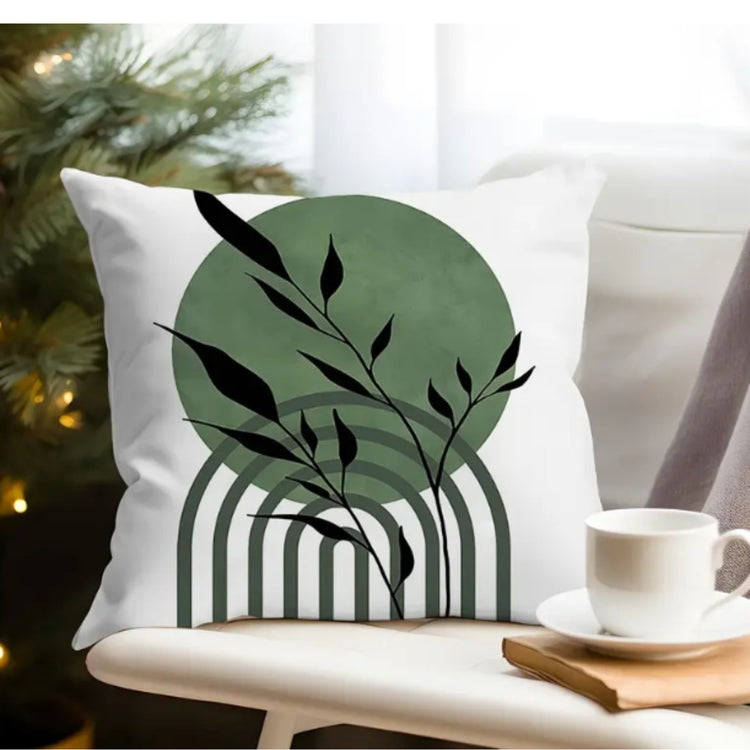 White cushion cover with a black leafy stem over a green circle and black lined arch.