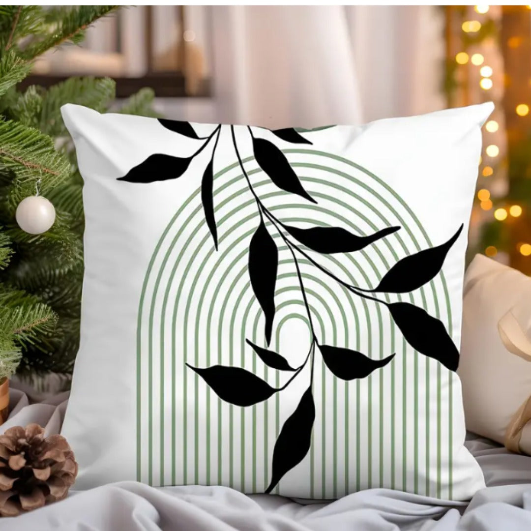 White cushion cover with a black leafy branch over a fine green lined arch.
