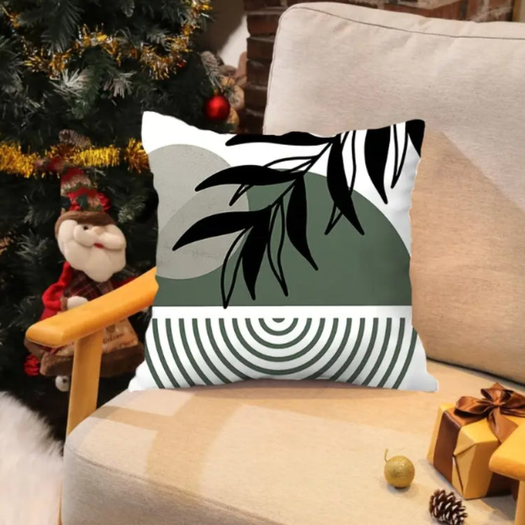 Cushion cover with black leaves over a green upper panel and fine curved black lines below.