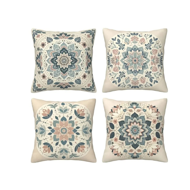 Four cream cushion covers with intricate muted blue, green and peach floral patterns.
