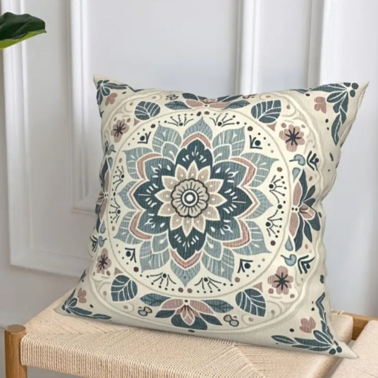 Cream cushion cover with a large blue floral medallion on a chair