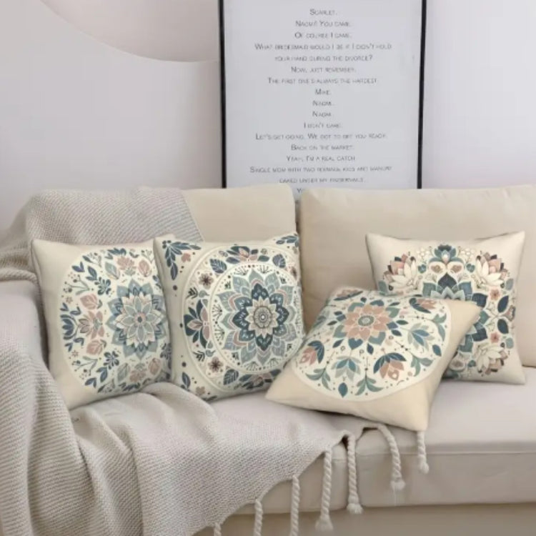 Cream cushion covers with muted blue and peach floral medallions on a sofa.
