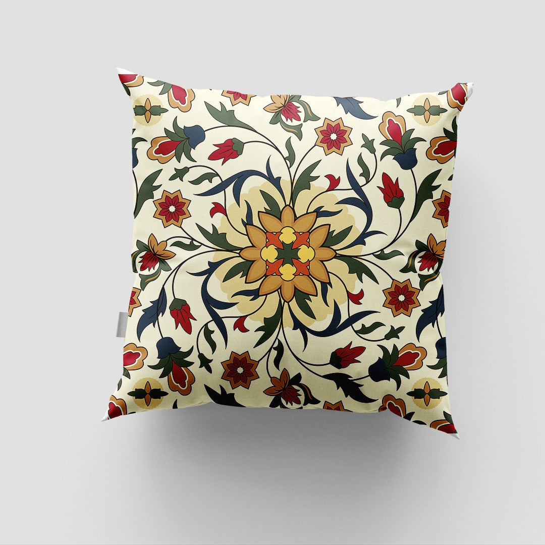 Cream cushion cover with an ornate yellow floral centre and curling green and red leaves.