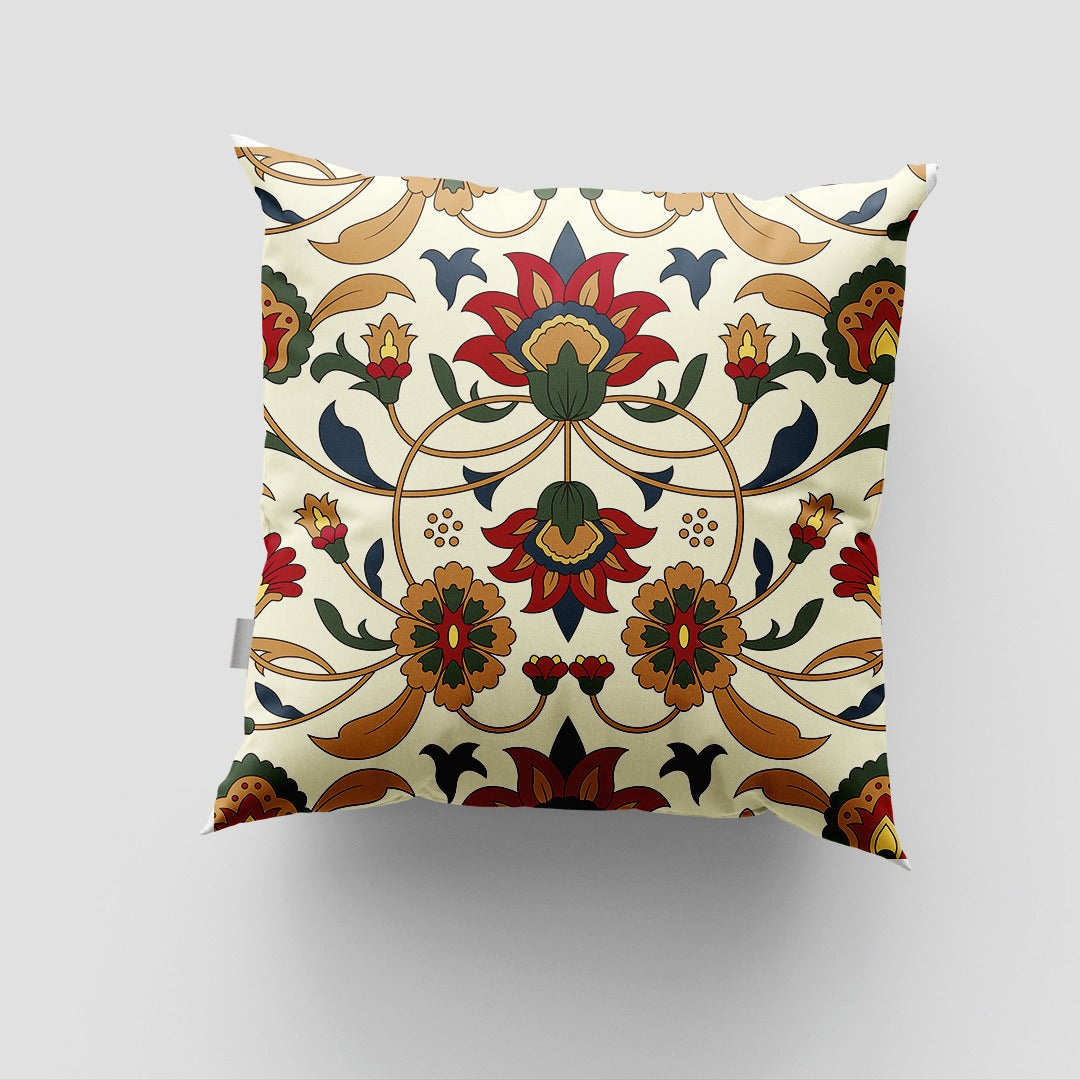 Cream cushion cover with a symmetrical green, red and ochre floral design.