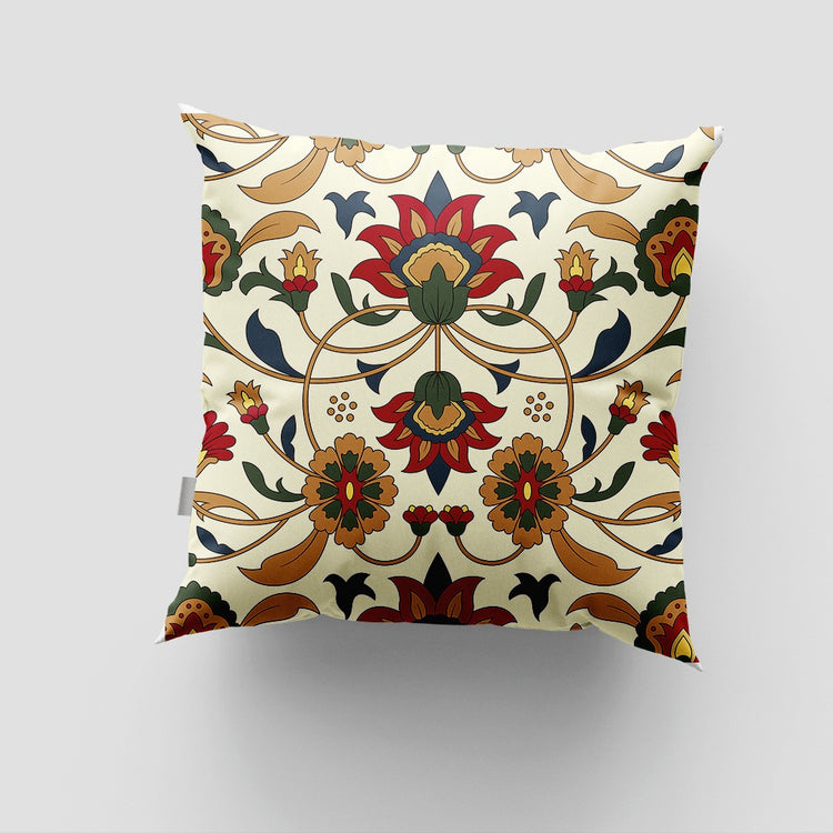 Cream cushion cover with a symmetrical green, red and ochre floral design.