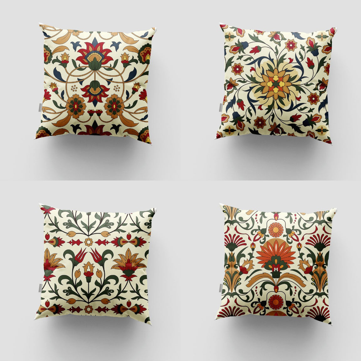 Four cream cushion covers with red, green and ochre floral motifs.
