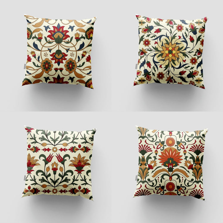 Four cream cushion covers with red, green and ochre floral motifs.