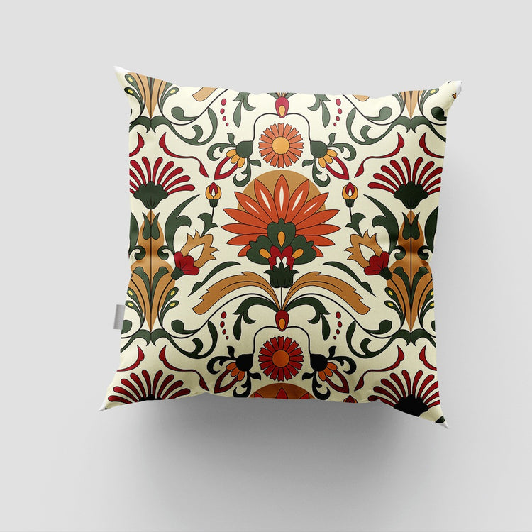Cream cushion cover with a large red flower and symmetrical green scrolling leaves.